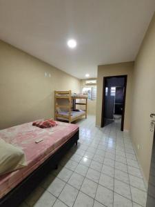 a bedroom with a bed and a chair in it at Cantinho do Mar in Bertioga +7 photos