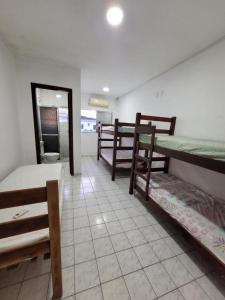 a room with bunk beds and a room with a toilet at Cantinho do Mar in Bertioga