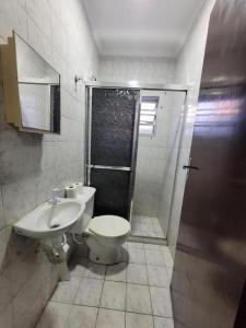 a bathroom with a toilet and a shower and a sink at Cantinho do Mar in Bertioga