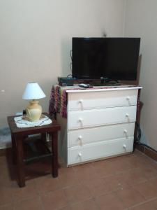 a dresser with a television and a table with a lamp at La Chili in Salta