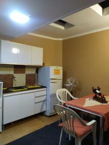 a kitchen with a table and a white refrigerator at La Chili in Salta +11 photos