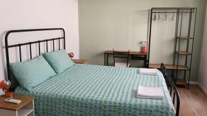 a bedroom with a bed with a green comforter at B&B Velocipede in Cervignano del Friuli