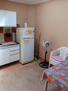 a kitchen with a refrigerator and a table and a fan at La Chili in Salta
