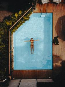 a woman is swimming in a swimming pool at Pousada Vila do Mar in Búzios