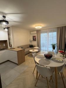a kitchen and a living room with a table and chairs at Luksusowy Apartament Onyks - Parking Gratis in Suwałki