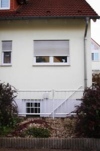 a white house with a window and a white railing at FeWoLaqua in Leipzig