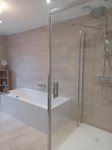 a bathroom with a bath tub and a shower at Chez Pépé in Limalonges +22 photos