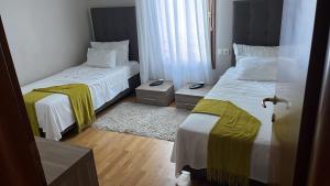 a bedroom with two beds and a window and a rug at Pine Residence at Lav Meridien Resort in Podstrana