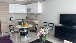 a kitchen with a table with chairs and a tv at Pine Residence at Lav Meridien Resort in Podstrana