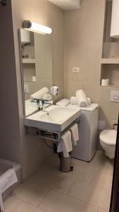 a bathroom with a sink and a toilet and a mirror at Pine Residence at Lav Meridien Resort in Podstrana +4 photos