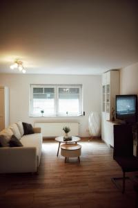 a living room with a couch and a table and a tv at FeWoLaqua in Leipzig