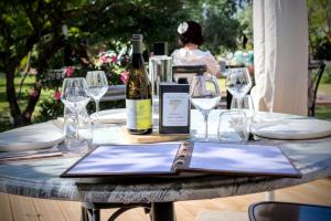 a table with glasses and a bottle of wine at Domaine de la violette in Orange