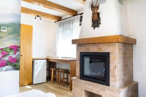 a living room with a brick fireplace with a tv at Carpatia Retezat in Clopotiva