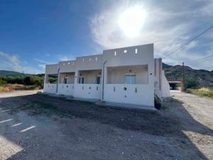 a white building with the sun in the sky at Prikas Apartments B in Kefalos