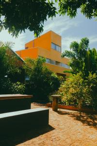 an orange building with trees in front of it at Pousada dos Bougainvilles in Manhã