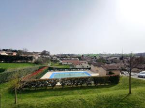 a swimming pool in the middle of a green field at Appartement à Nailloux in Nailloux +2 photos