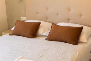 a bed with two brown pillows on top of it at Apartment Solis 6 in Stara Novalja