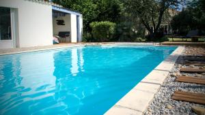 a swimming pool with blue water in a yard at Domaine de la violette in Orange +13 photos