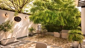 a patio with chairs and a table and trees at Hotel Casa Vivaldi in Mérida