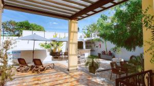 a patio with chairs and tables and umbrellas at Hotel Casa Vivaldi in Mérida