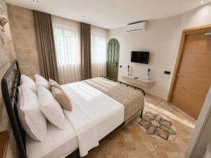 a bedroom with a large bed and a television at LA BİEN ALAÇATI by ALİİS in Çeşme