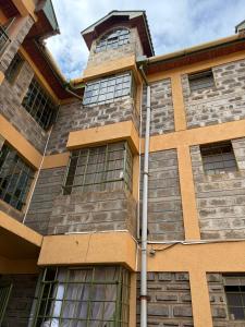 a building with windows on the side of it at Kendi Stays - Rustic Penthouse Attic in Eldoret