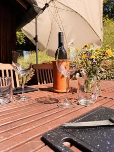 a wooden table with glasses and a bottle of wine at Ferienhaus Landliebe 1753 in Bad Gleichenberg