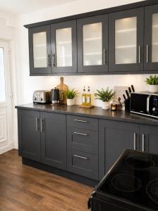 a kitchen with black cabinets and a counter top at Modern 3BR Close to Durham Centre in Gilesgate