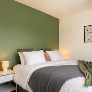 a bedroom with a large bed with a green wall at Modern 3BR Close to Durham Centre in Gilesgate