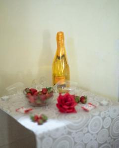 Eine Flasche Wein und eine Schale Erdbeeren auf einem Tisch in der Unterkunft QUART0 GREC0 Suite 15 in Altamura