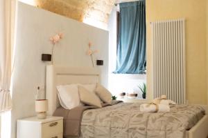 ein Schlafzimmer mit einem Bett, auf dem ein Teddybär liegt in der Unterkunft QUART0 GREC0 Suite 15 in Altamura + 12 Fotos