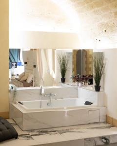 ein Badezimmer mit einer großen weißen Badewanne in einem Zimmer in der Unterkunft QUART0 GREC0 Suite 15 in Altamura