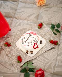 eine Torte auf einem Bett mit Rosen in der Unterkunft QUART0 GREC0 Suite 15 in Altamura