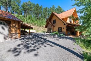 a driveway in front of a house with a garage at Destiny Luxury Log Cabin in Sturgis