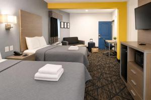 una camera d'albergo con due letti e una televisione di Hotel Royale IAH Airport North Houston I-45 a Houston