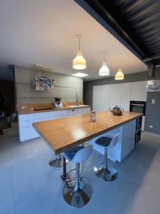 a kitchen with a wooden table and two bar stools at Villa Millau-gorges du Tarn in Aguessac