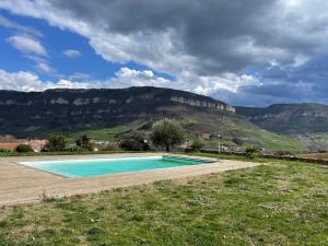 a swimming pool in a field with mountains in the background at Villa Millau-gorges du Tarn in Aguessac
