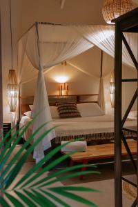 a bedroom with a canopy bed and a table at Na Villa dos Algodões in Marau