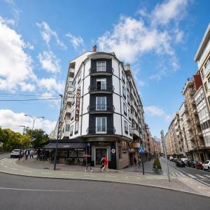 a tall white building on the corner of a street at Hostal Cafetería La Rotonda in Ourense