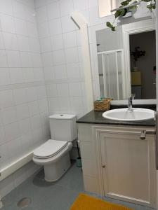 a white bathroom with a toilet and a sink at Apartamento Nordés in A Guarda