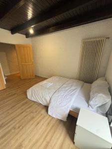 a bedroom with a white bed and a table at Himalaya Budget Inn in Niederanven