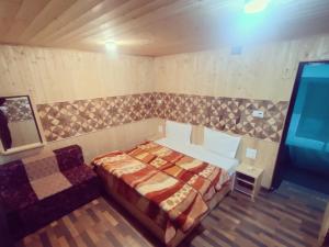 a bedroom with a bed and a chair in it at New Heaven Rose in Pahalgām +4 photos