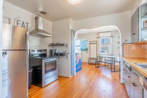 a kitchen with a stainless steel refrigerator and wooden floors at Midtown Sanctuary w Pac-Man in Reno +13 photos
