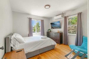 a bedroom with a bed and a blue chair at Midtown Sanctuary w Pac-Man in Reno
