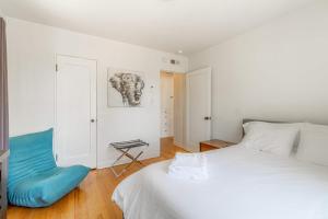 a bedroom with a white bed and a blue couch at Midtown Sanctuary w Pac-Man in Reno
