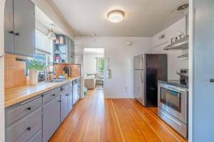 a kitchen with wooden floors and stainless steel appliances at Midtown Sanctuary w Pac-Man in Reno