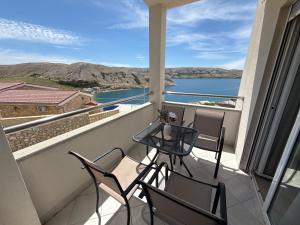 a balcony with chairs and a table and a view of the water at Apartments by Resort Čulina in Metajna