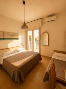 a bedroom with a large bed and a window at Hotel Gianlore in Milano Marittima