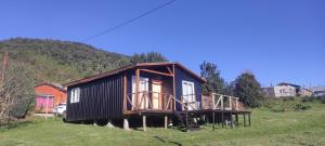 a small house sitting on top of a field at Cabaña lomas de chaica in Puerto Montt