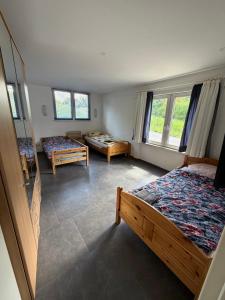a bedroom with two beds and two windows at Monteurzimmer Ferienwohnung in Bad Gandersheim